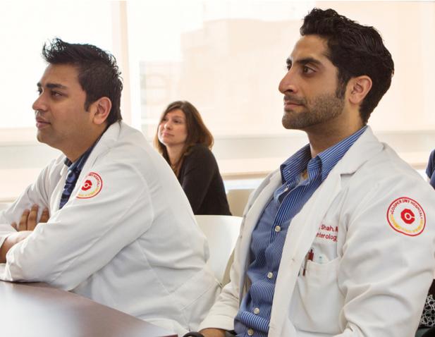Medical residents and students attentively listening during a classroom lecture at Cooper University Health Care.
