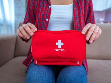 Photo of a woman holding a first aid kit.